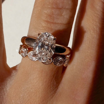 An oval solitaire with a thick yellow gold band 